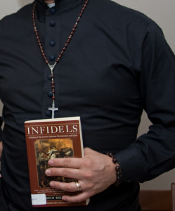 Priest holding a book about Infidels